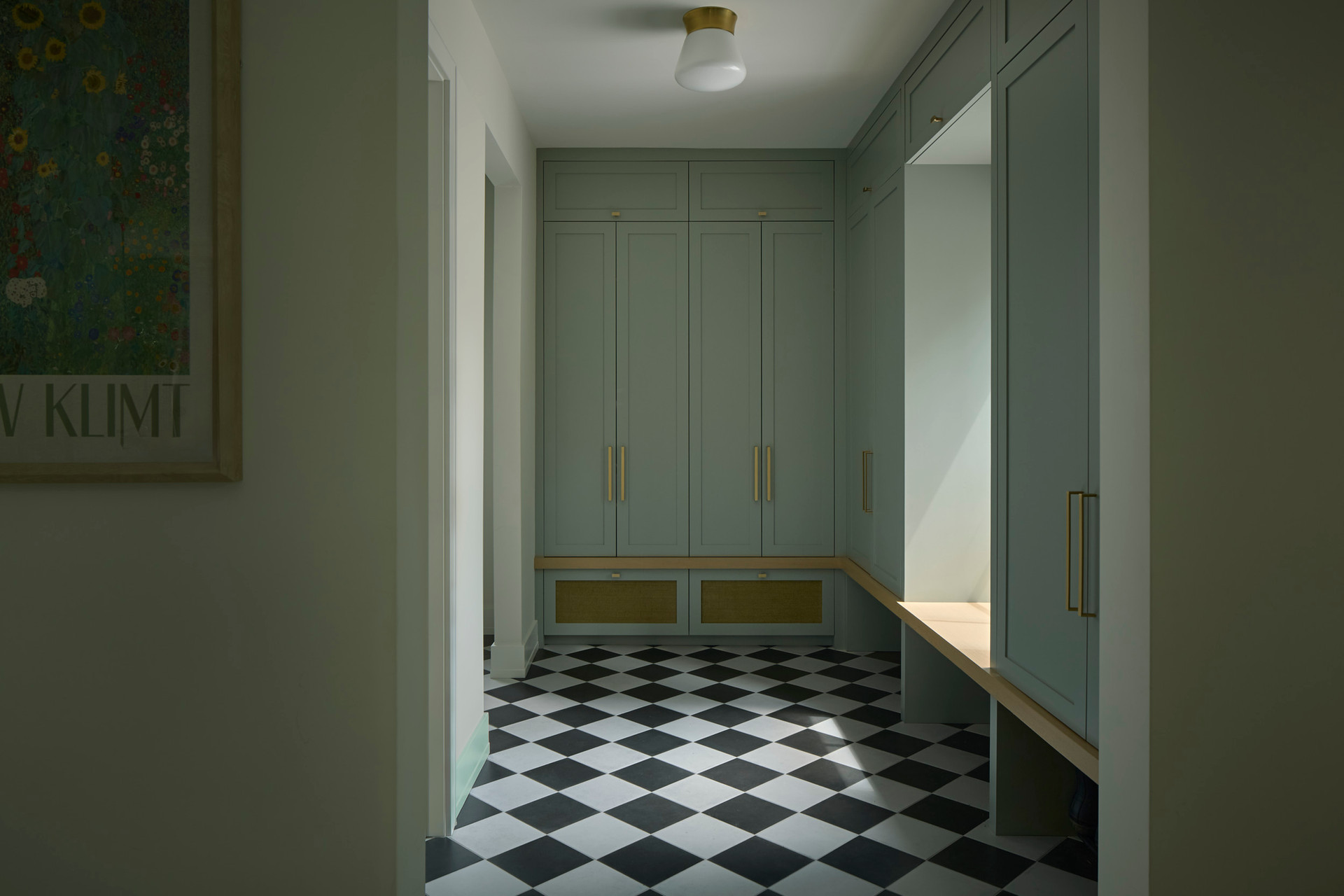 Custom sage green mudroom cabinetry with brass hardware and checkered floor — House on Peter Lowe