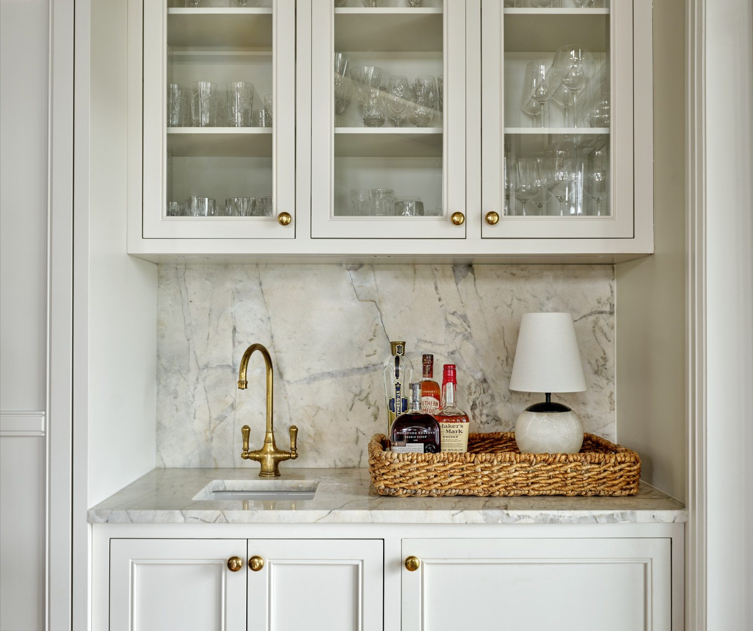 Butler pantry with custom glass-front upper cabinetry