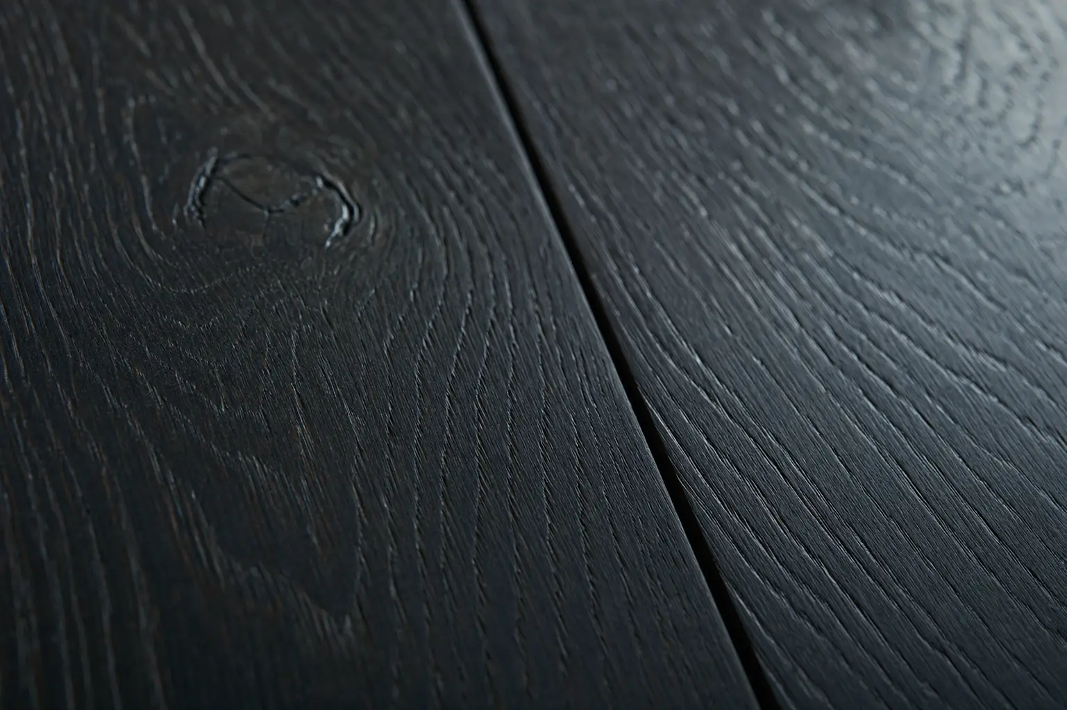 Wide-plank jet-black stained white oak cabinetry material sample